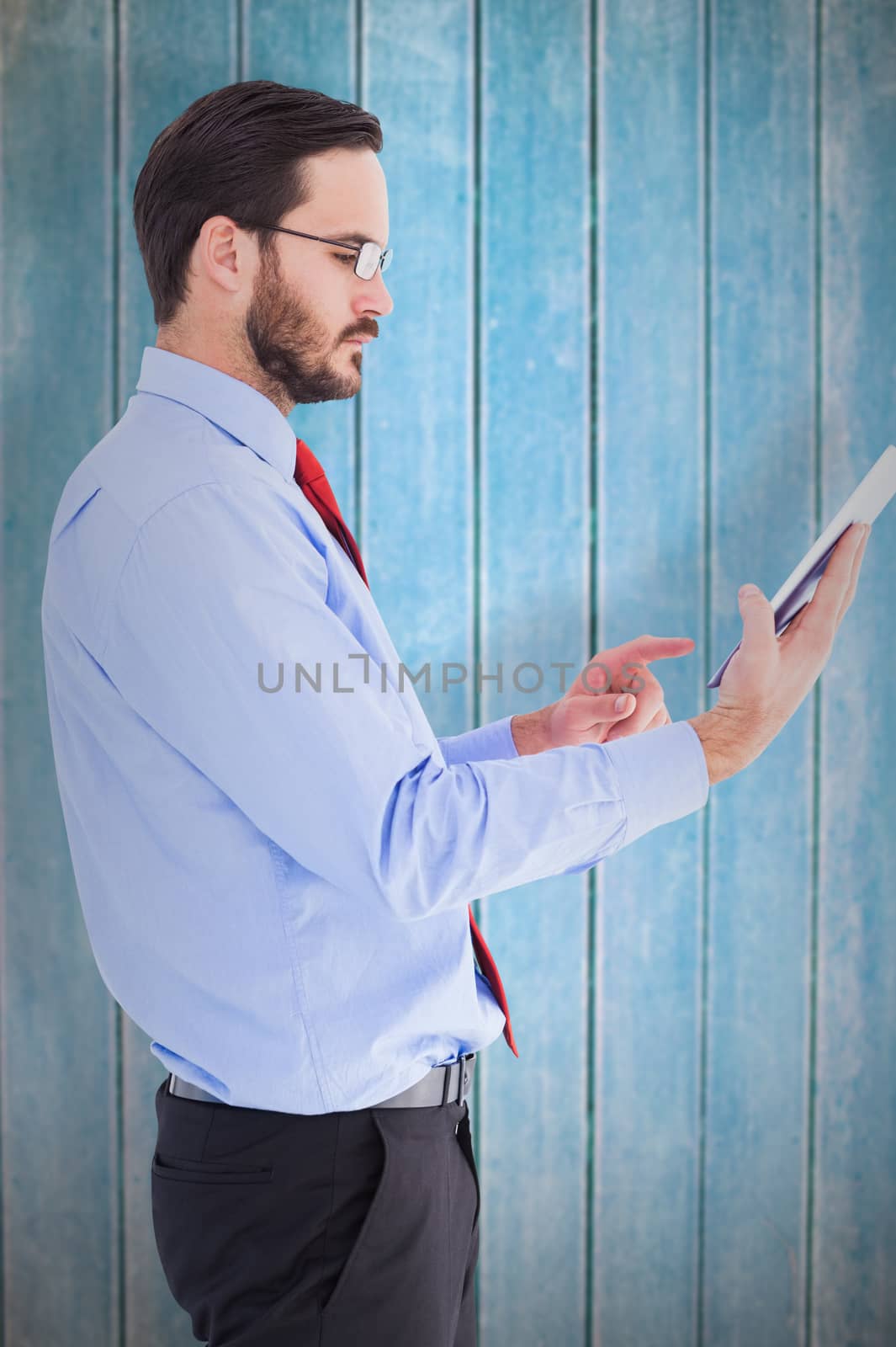 Composite image of businessman scrolling on his digital tablet by Wavebreakmedia