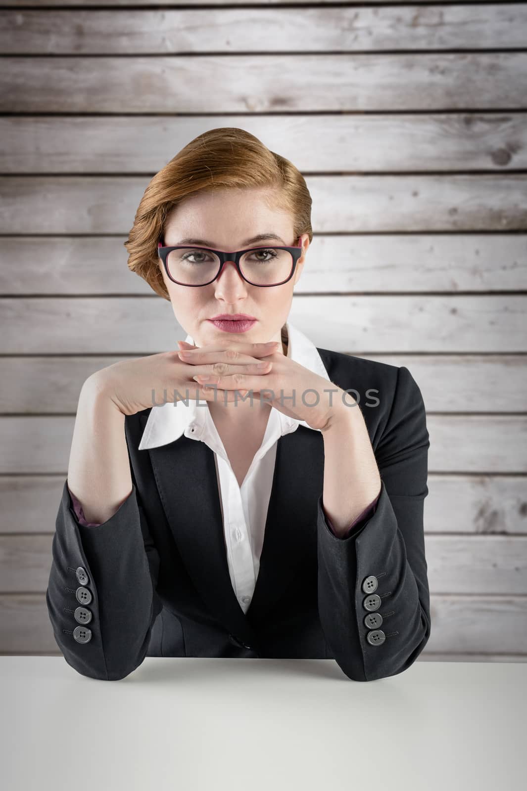 Composite image of redhead businesswoman sitting at desk by Wavebreakmedia