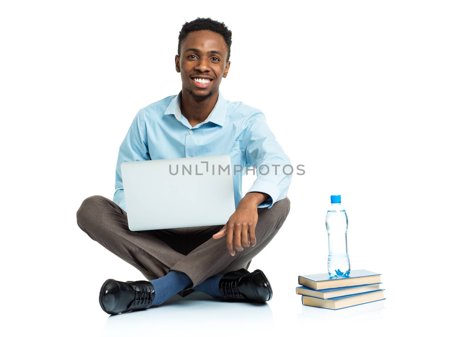 Happy african american college student with laptop, books and bottle of water sitting on white background