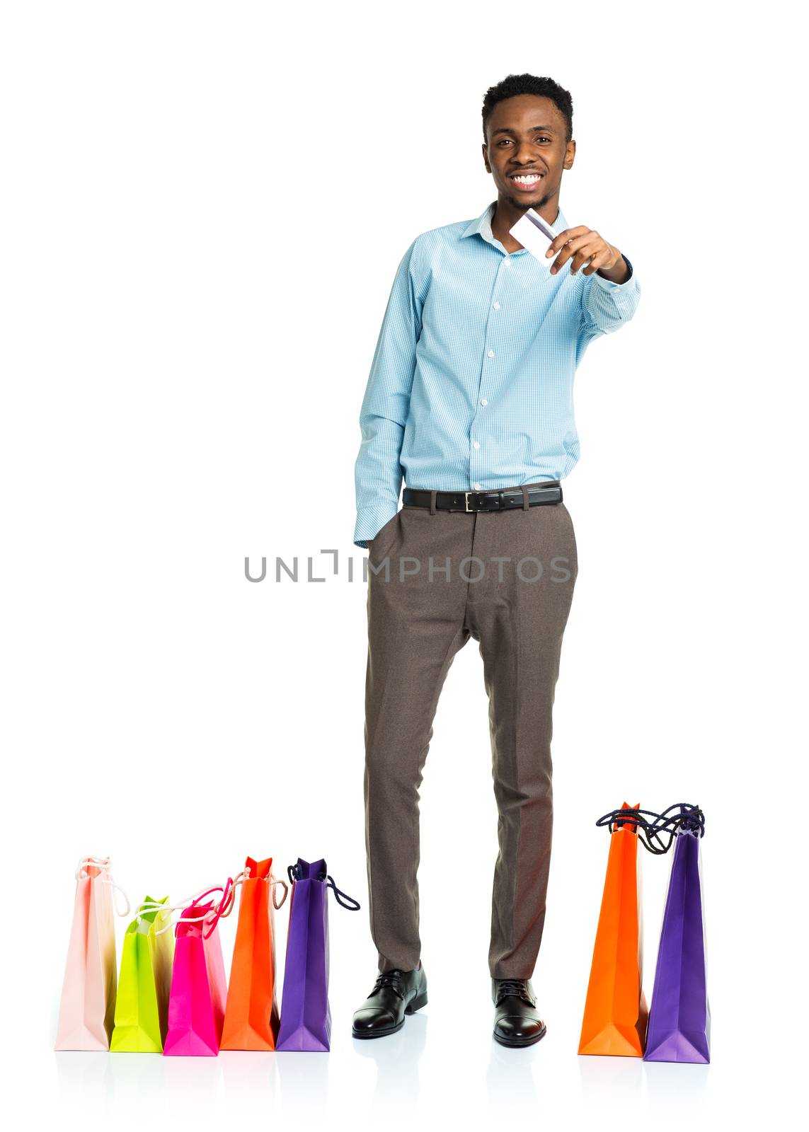 Happy african american man with shopping bags and holding credit card on white. Holidays concept