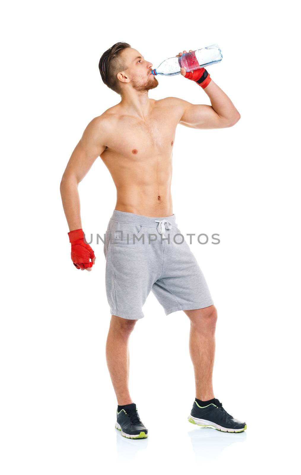 Sport attractive man wearing boxing bandages and drinking fresh water on the white background