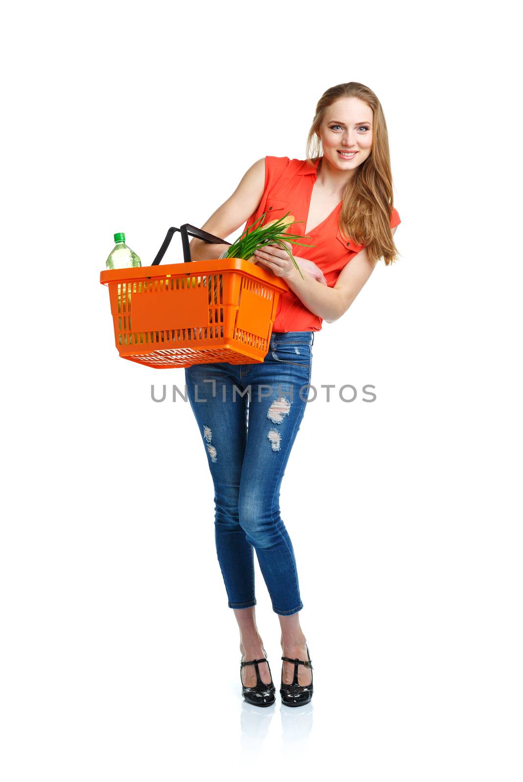 Happy young woman holding a basket full of healthy food on white background. Shopping