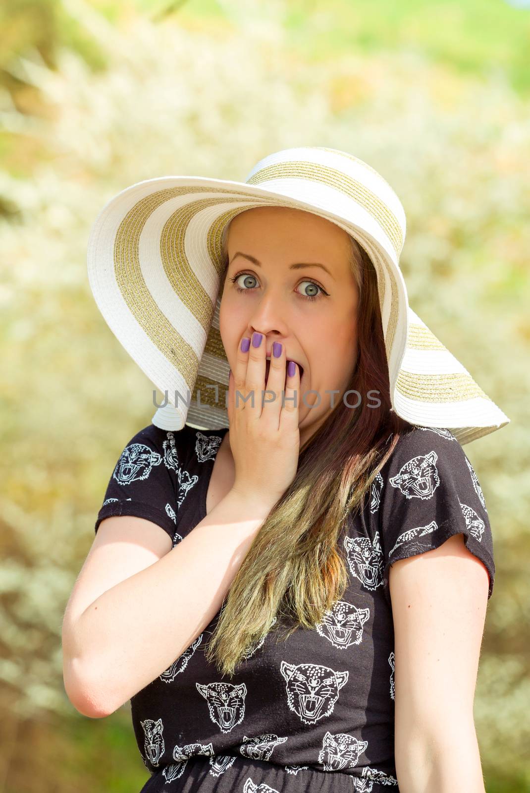 Portrait of grimace cheerful fashionable woman in stylish hat and frock. Crazy happy brunette girl with long hair in warm spring day