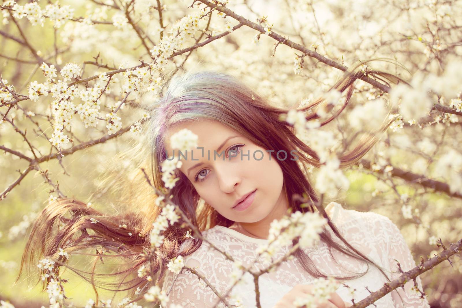 Portrait of cheerful fashionable woman in spring blooming tree by artush