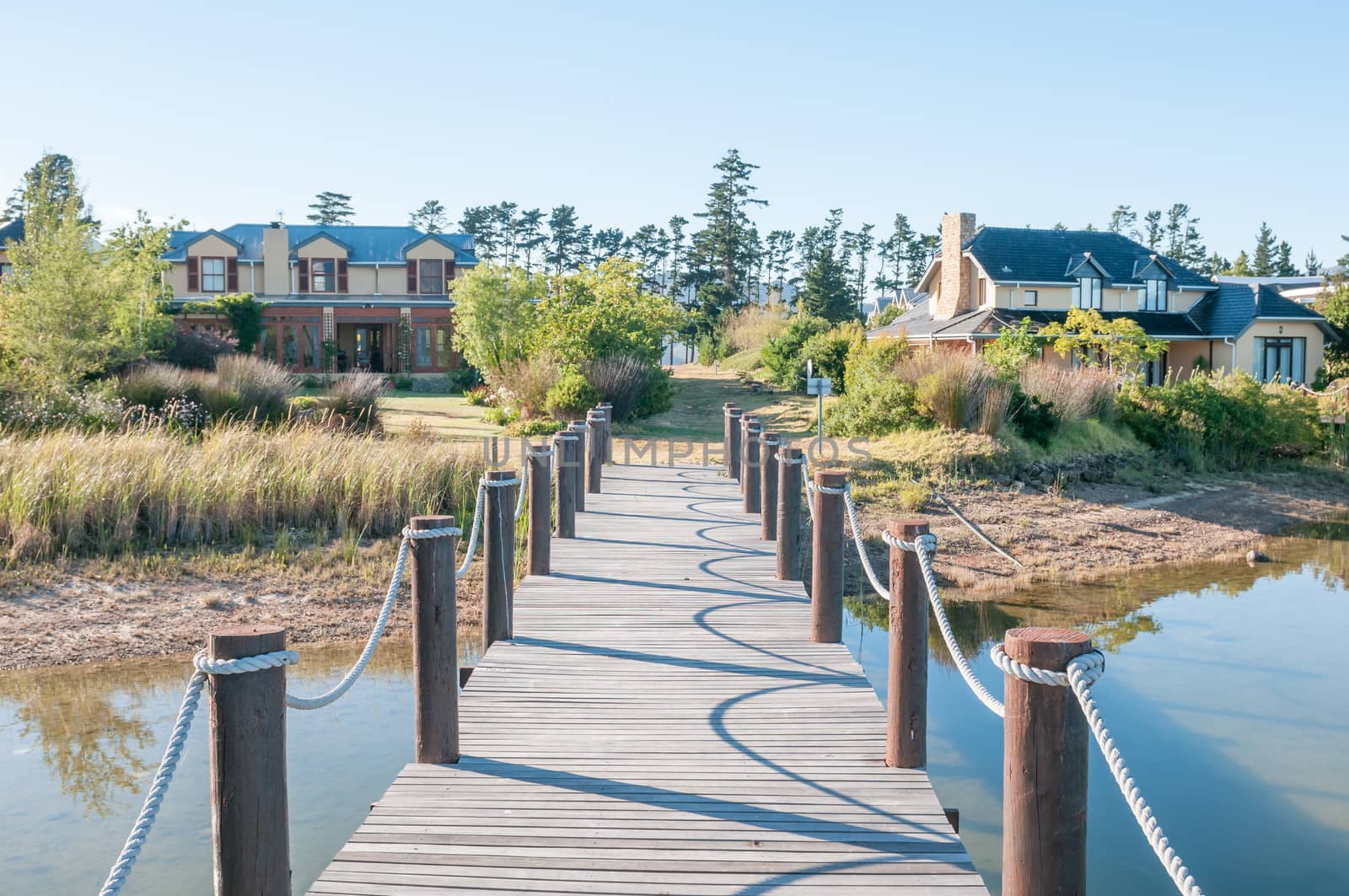 CAPE TOWN, SOUTH AFRICA - DECEMBER 18, 2014: Houses next to a dam with jetty on the Wedderville Estate near Sir Lowrys Pass