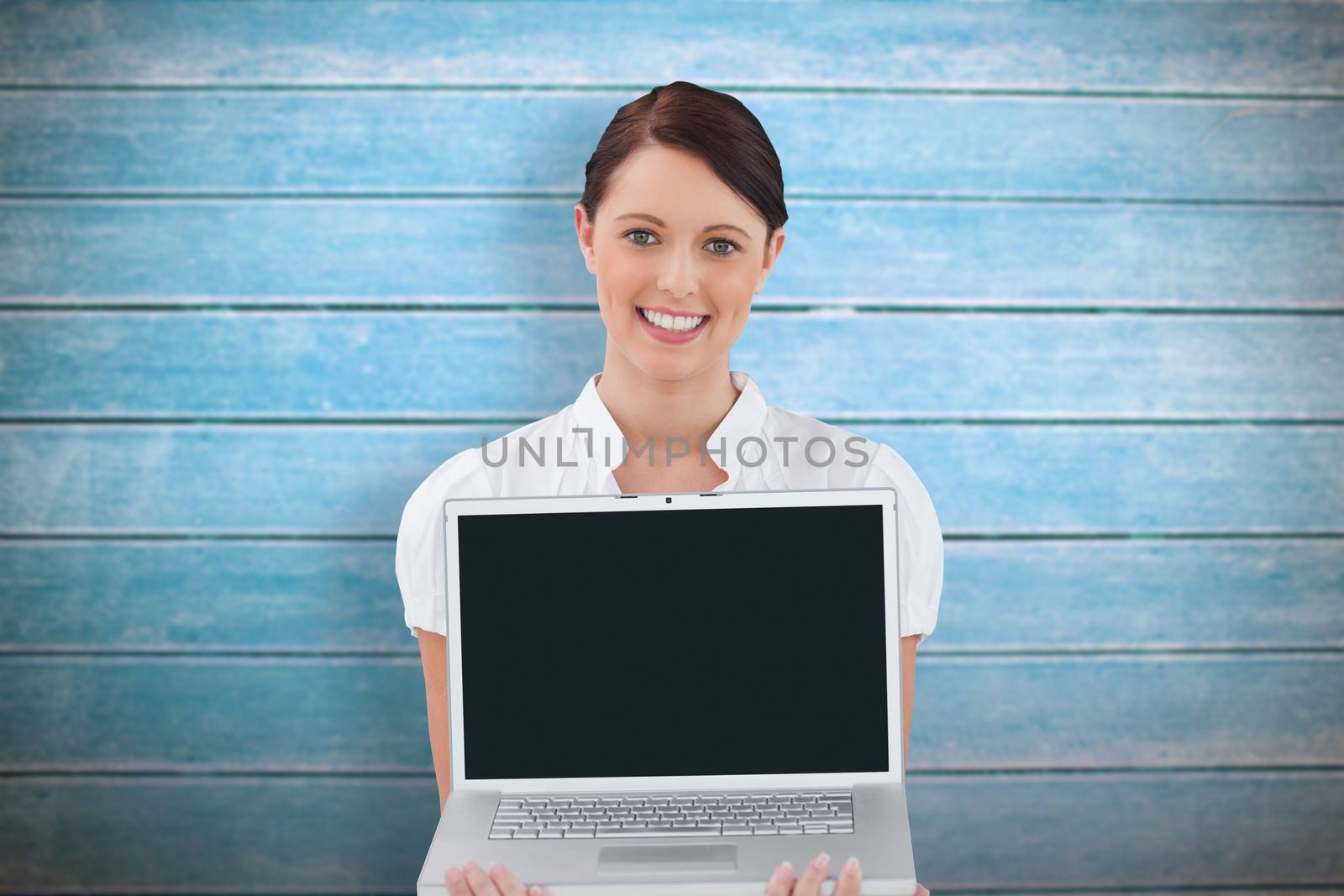 Composite image of tradeswoman showing notebook with colleagues behind her by Wavebreakmedia