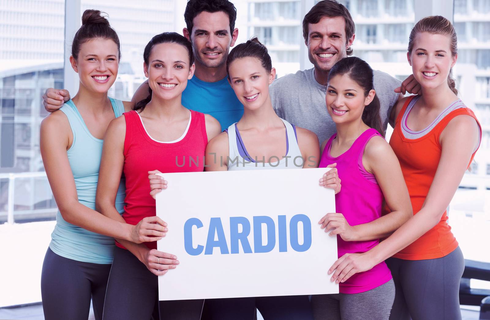 The word cardio against fit smiling people holding blank board