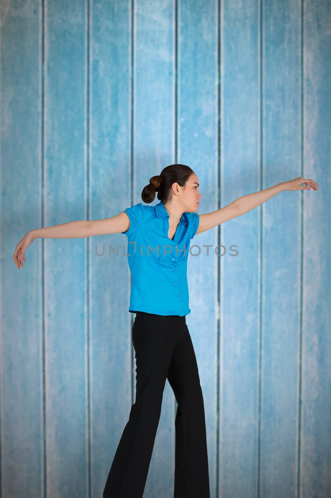 Young businesswoman hanging like a puppet against wooden planks