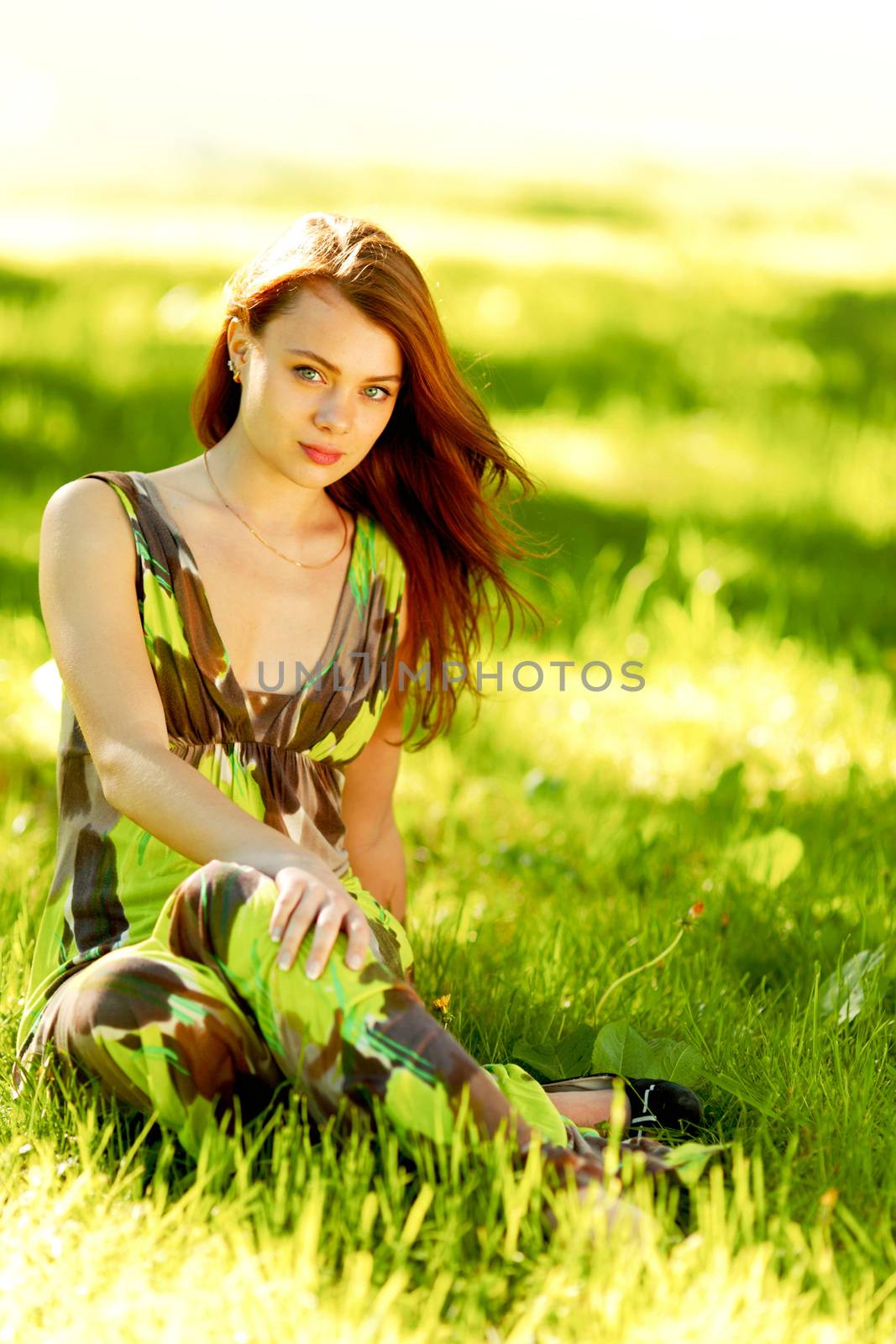 Woman sitting in a green field by Yellowj