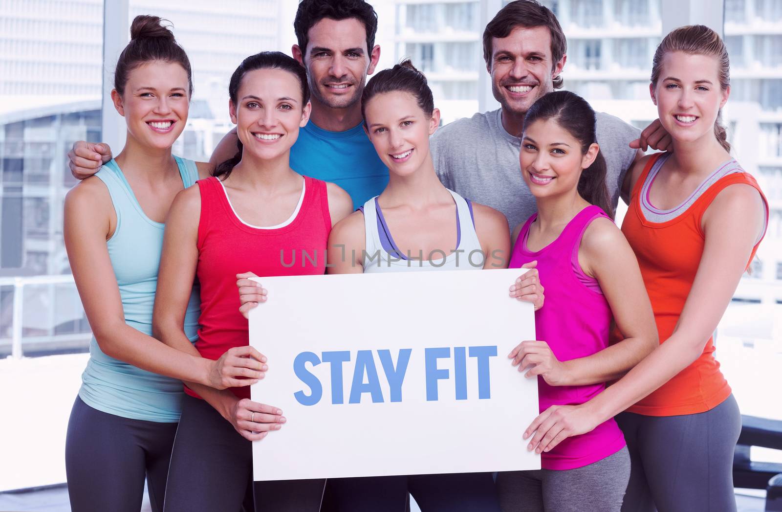 The word stay fit against fit smiling people holding blank board
