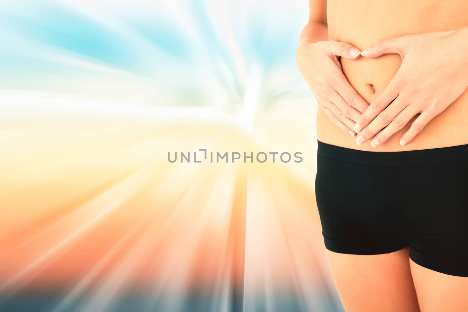 Closeup mid section of a fit woman in black shorts against abstract background