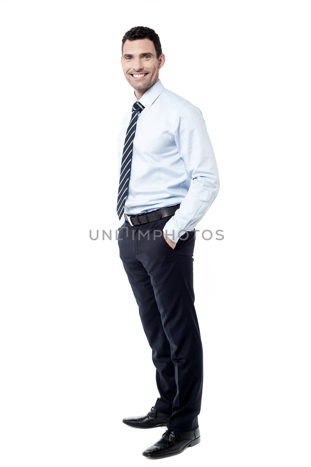 Full length of male executive with hands in pockets