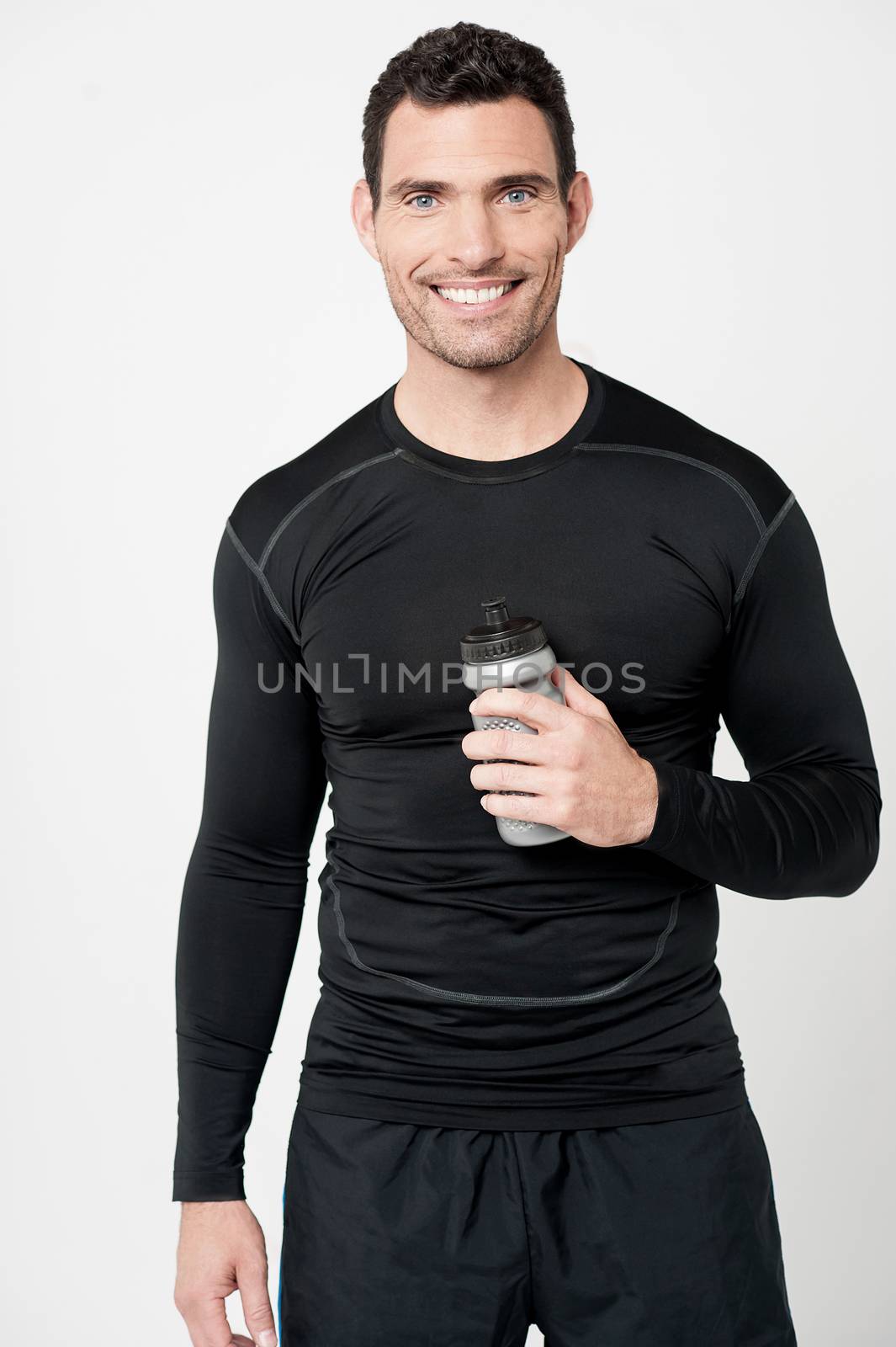 Smiling male athlete with sipper bottle