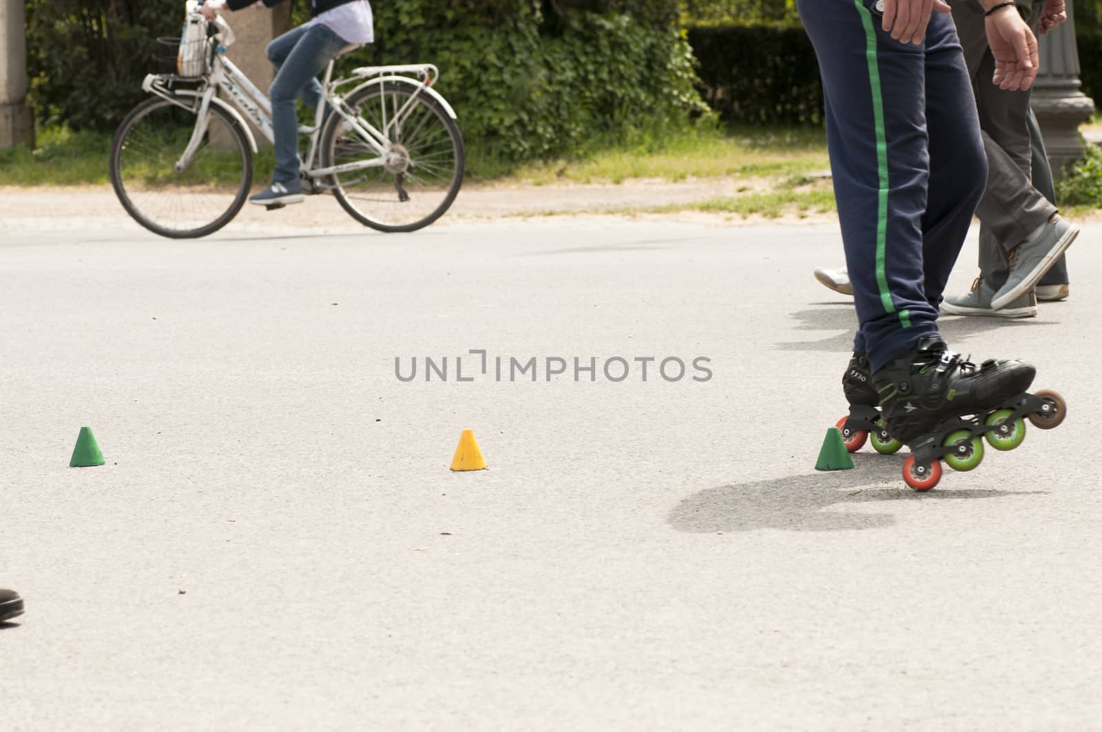 Roller skater practicing slalom along a line of cones on asphalt.