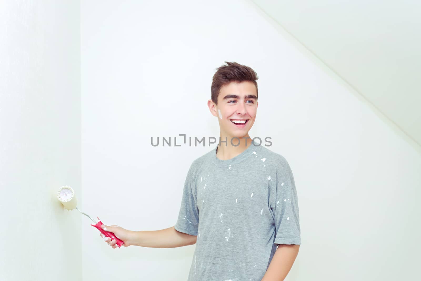 teenager painting wall to white at home by artush
