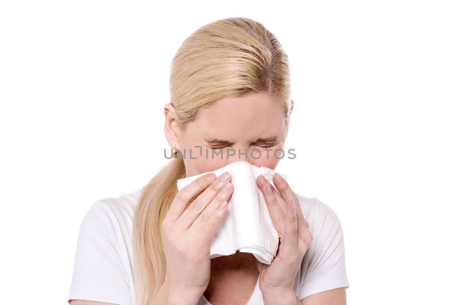 Unhealthy woman blowing  her nose into a tissue