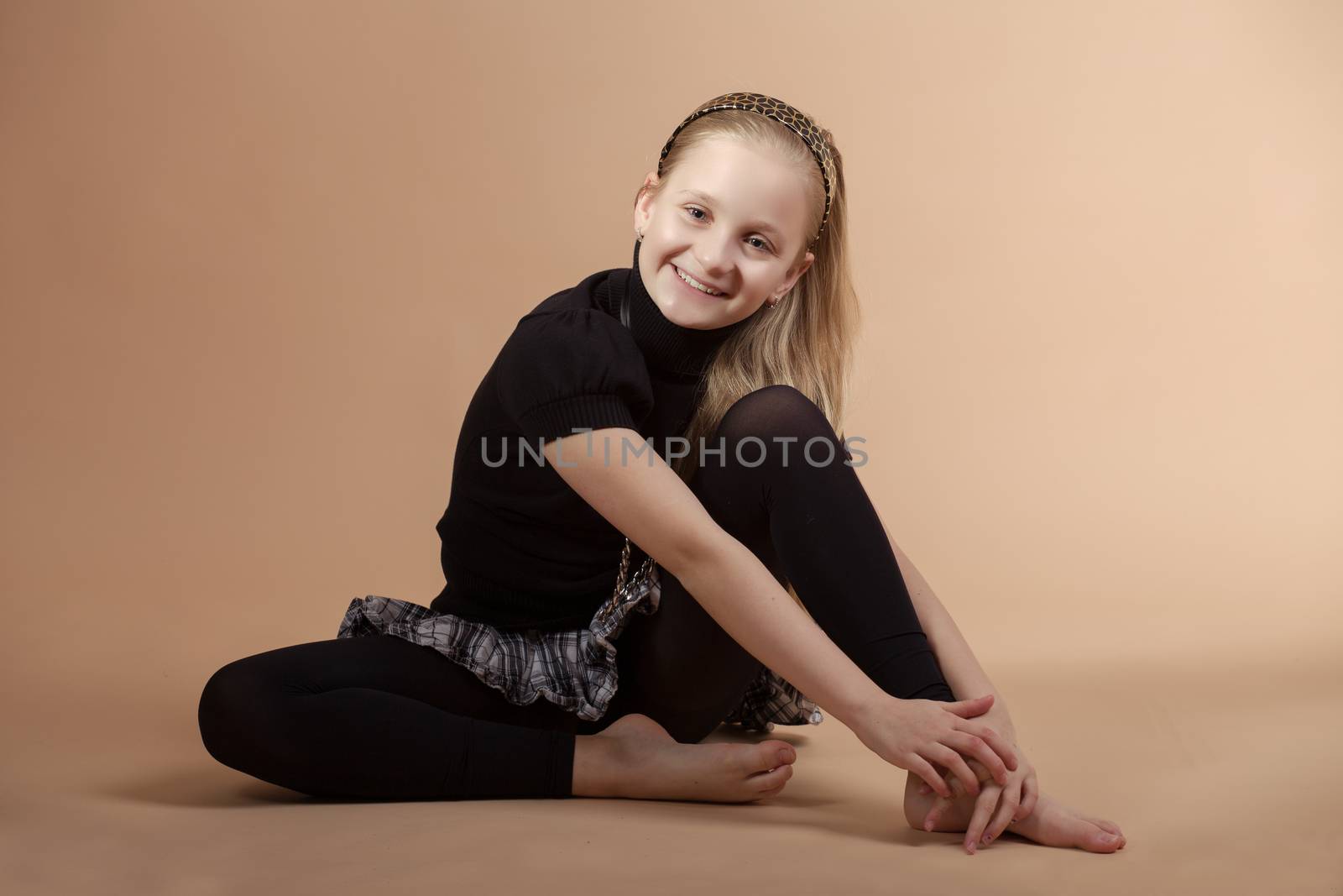 fashion smiling european little long hair blonde girl training yoga in atelier