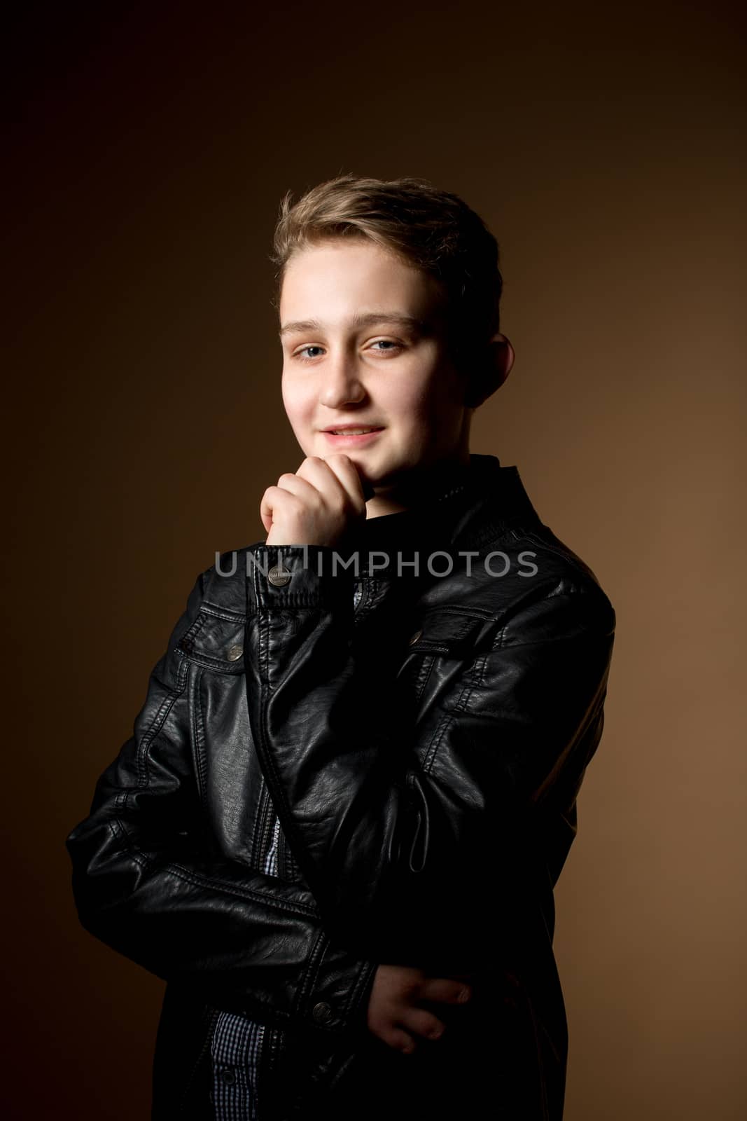 portrait of handsome appealing young man on dark beige background