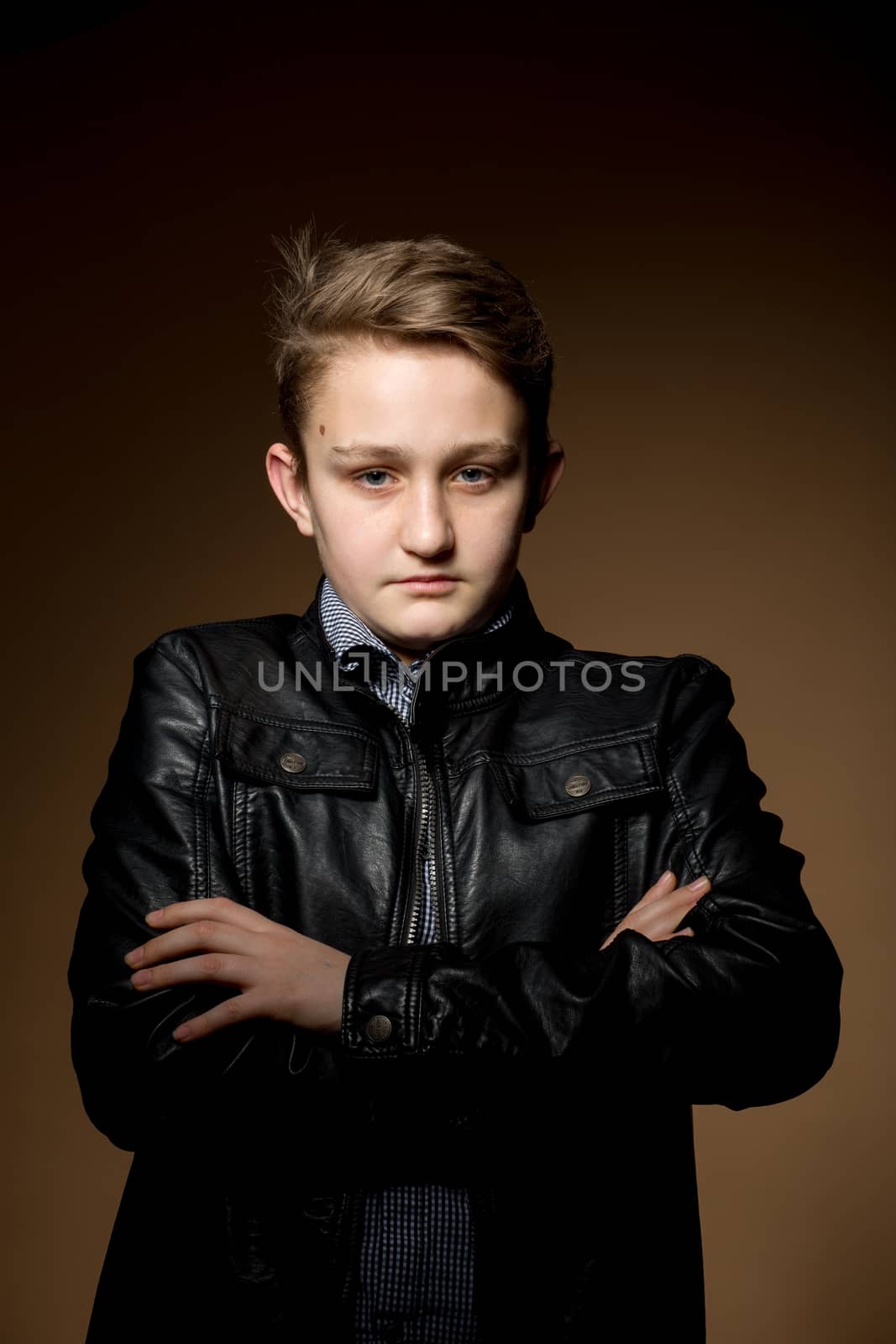 portrait of handsome appealing young man on dark beige background