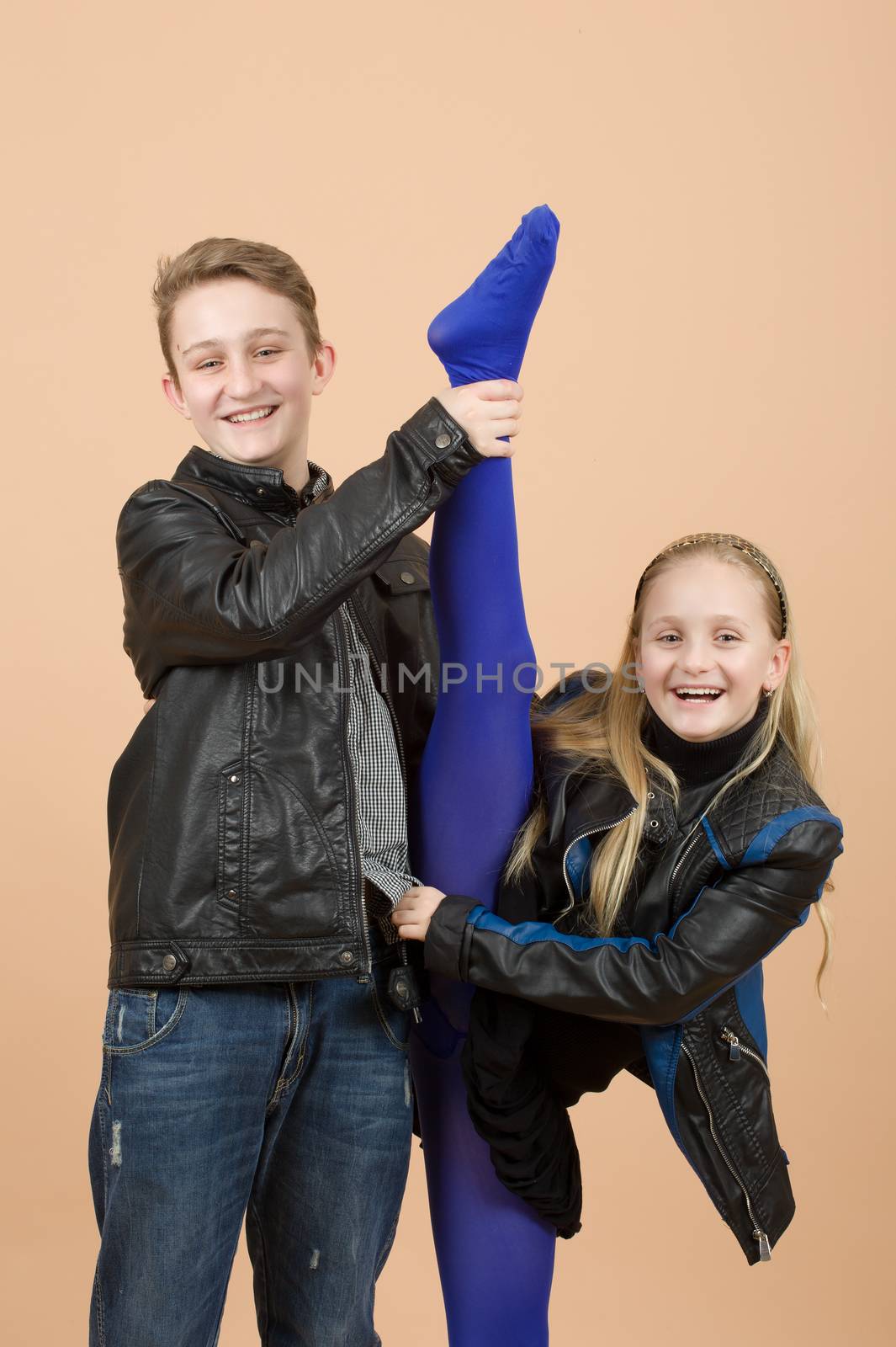 fashion smiling european little long hair blonde girl and her brother training yoga in atelier