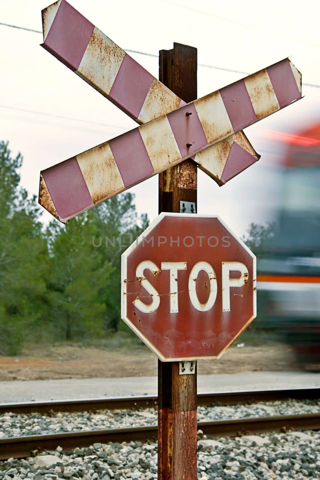 Railway stop sign with train movement blur off to the right. by emadrazo