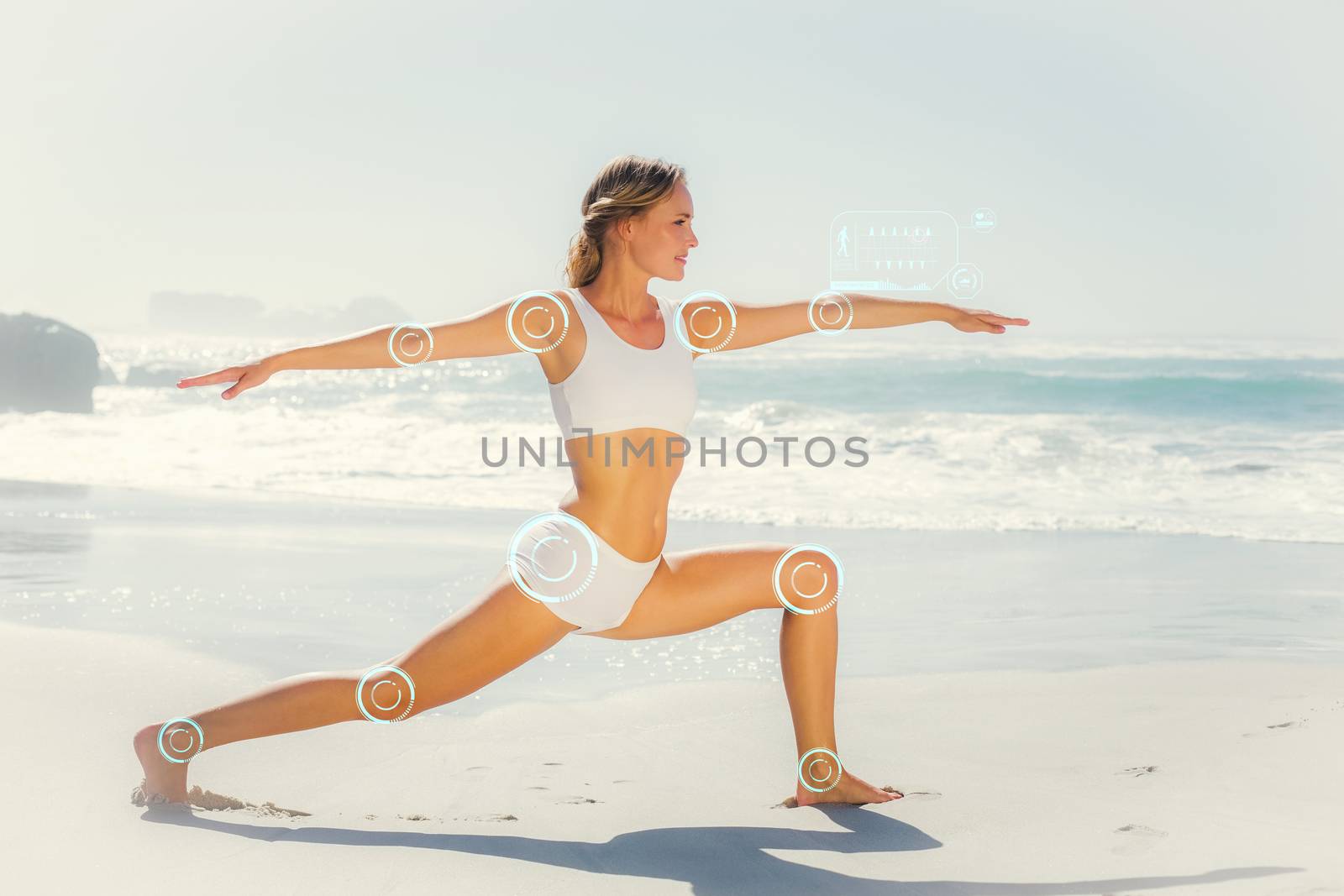 Gorgeous blonde in warrior pose by the sea against fitness interface