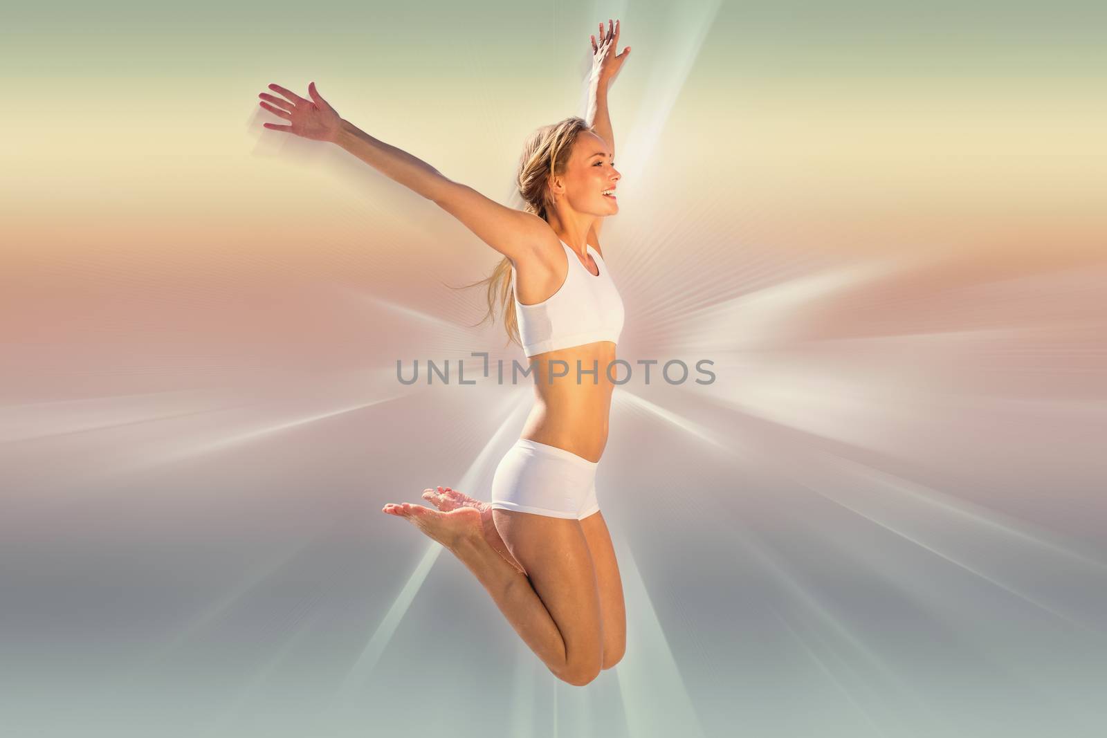 Gorgeous fit blonde jumping with arms out against abstract background