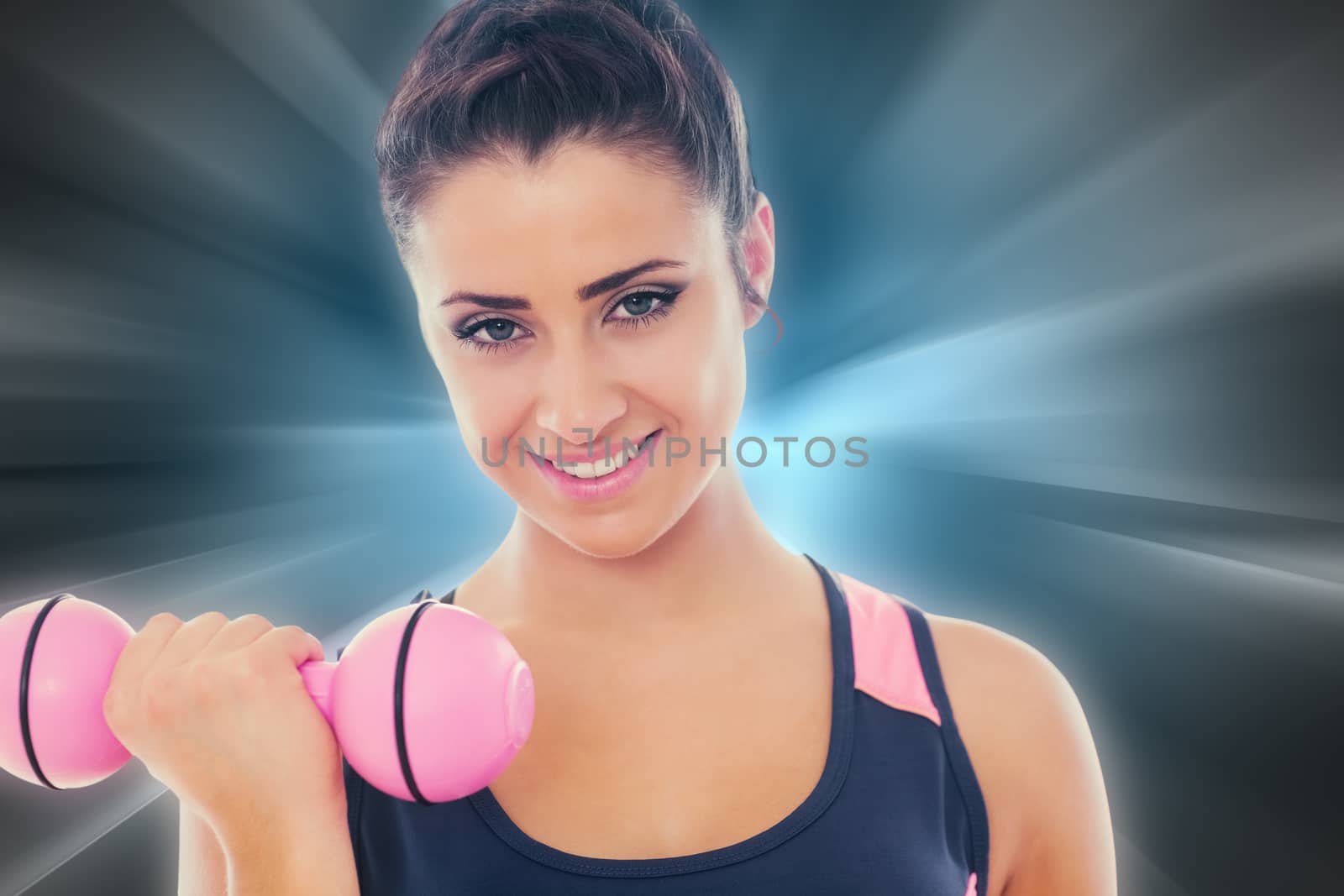 Woman lifting dumbbell weight with friend in background at gym against abstract background