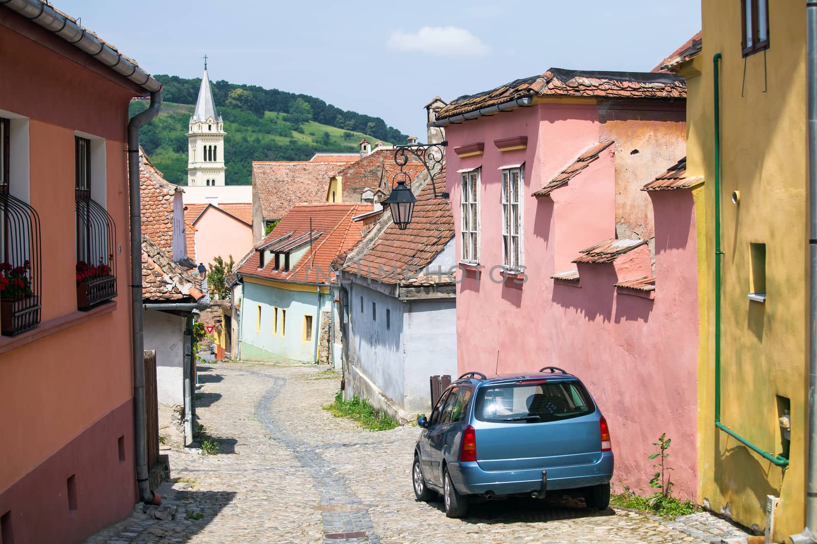 Old paved stone street with colored houses from Old Turda medieval city center, Turda, Romania