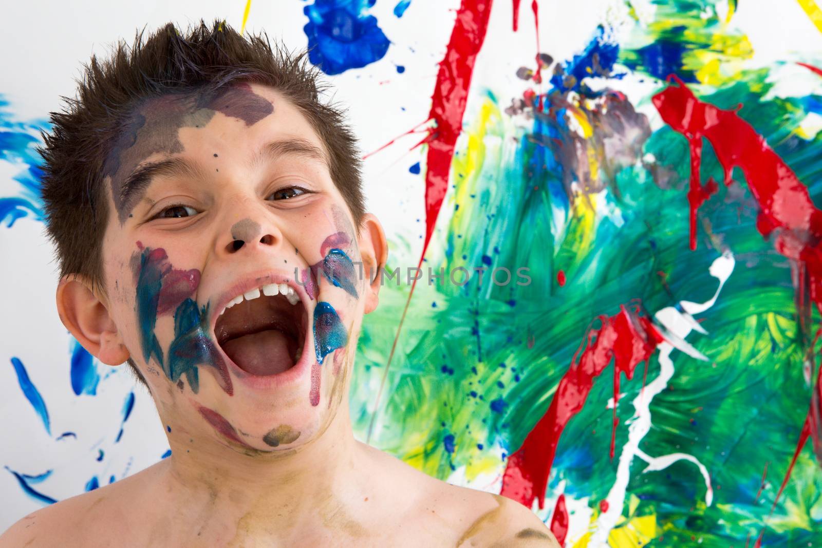Funny little boy with paint splodges on his face by coskun