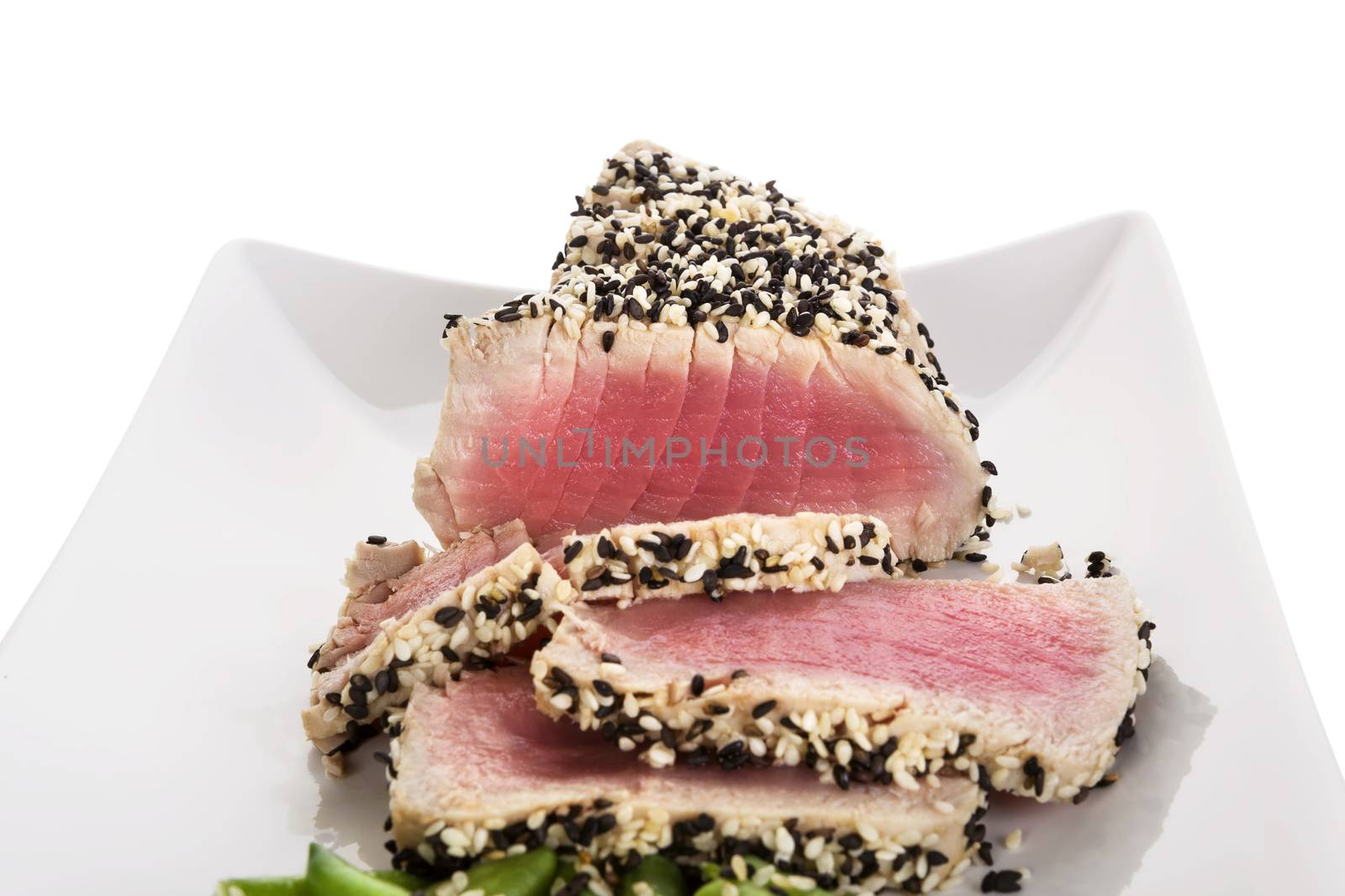 Tuna slices with white and black sesame seeds on white plate. Culinary seafood, healthy eating.