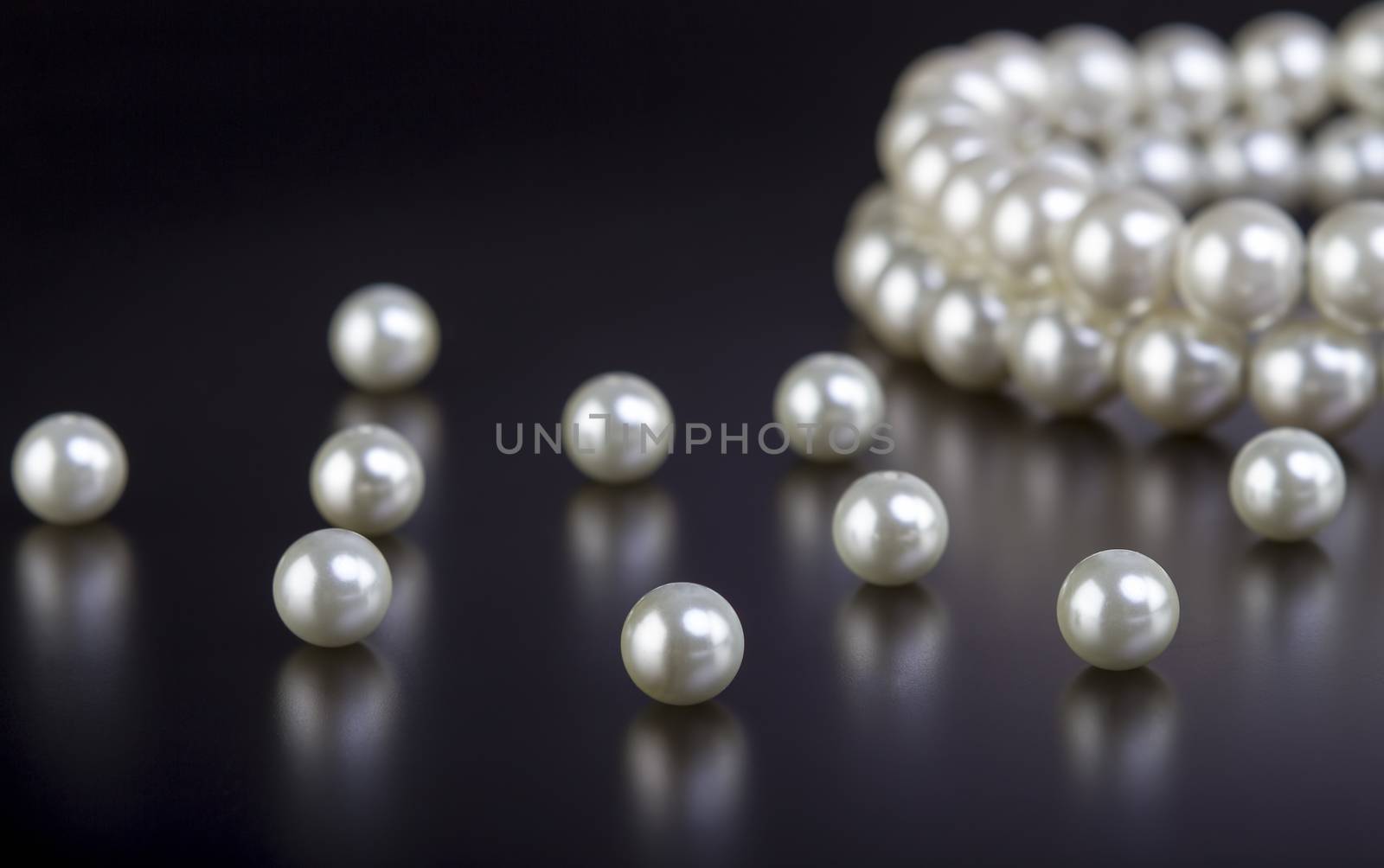 White pearls necklace on black by manaemedia