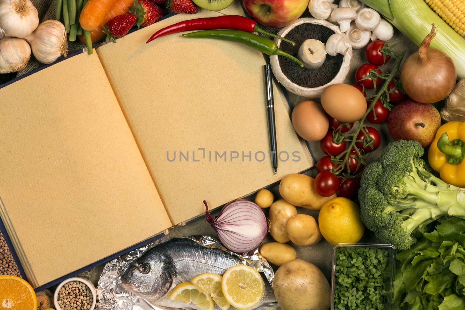 Staple foods - Fruit, Fish and Vegetables with the blank pages of a recipe book - Space for text.