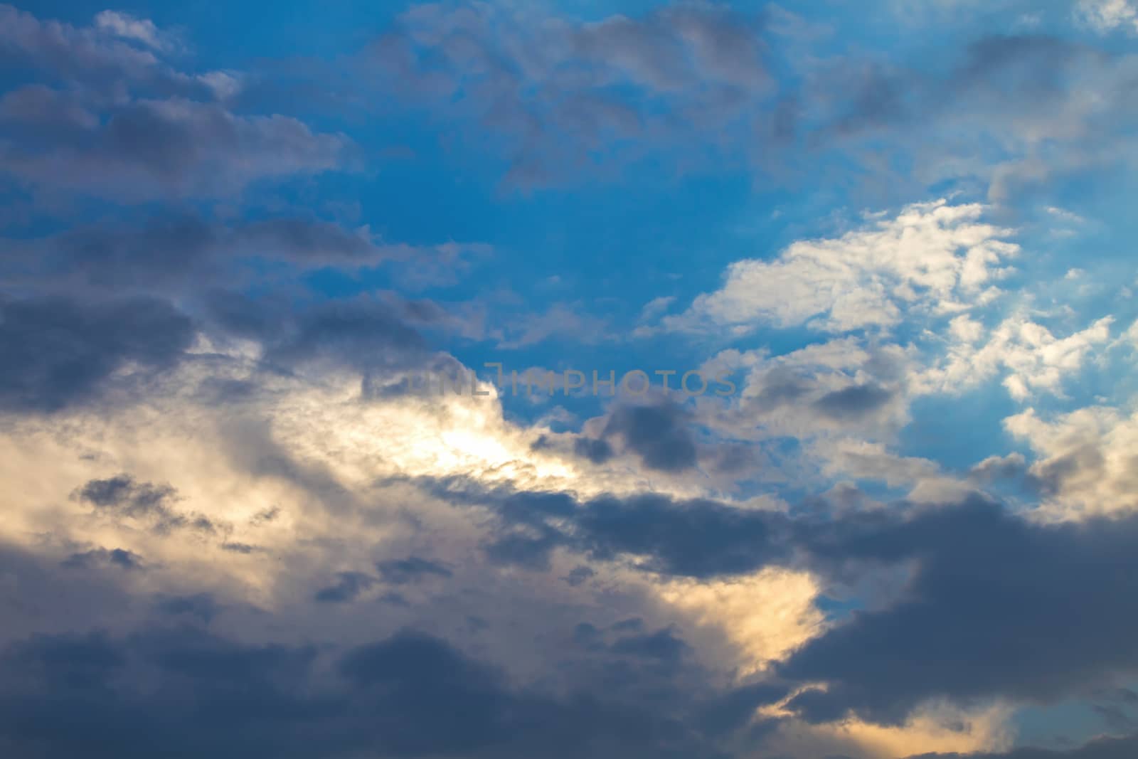 Sun under clouds on blue sky background