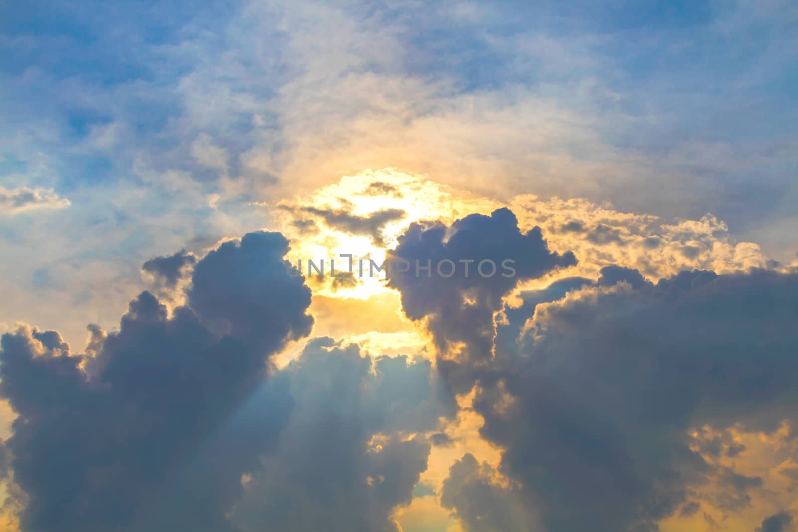 Sun under clouds on blue sky background