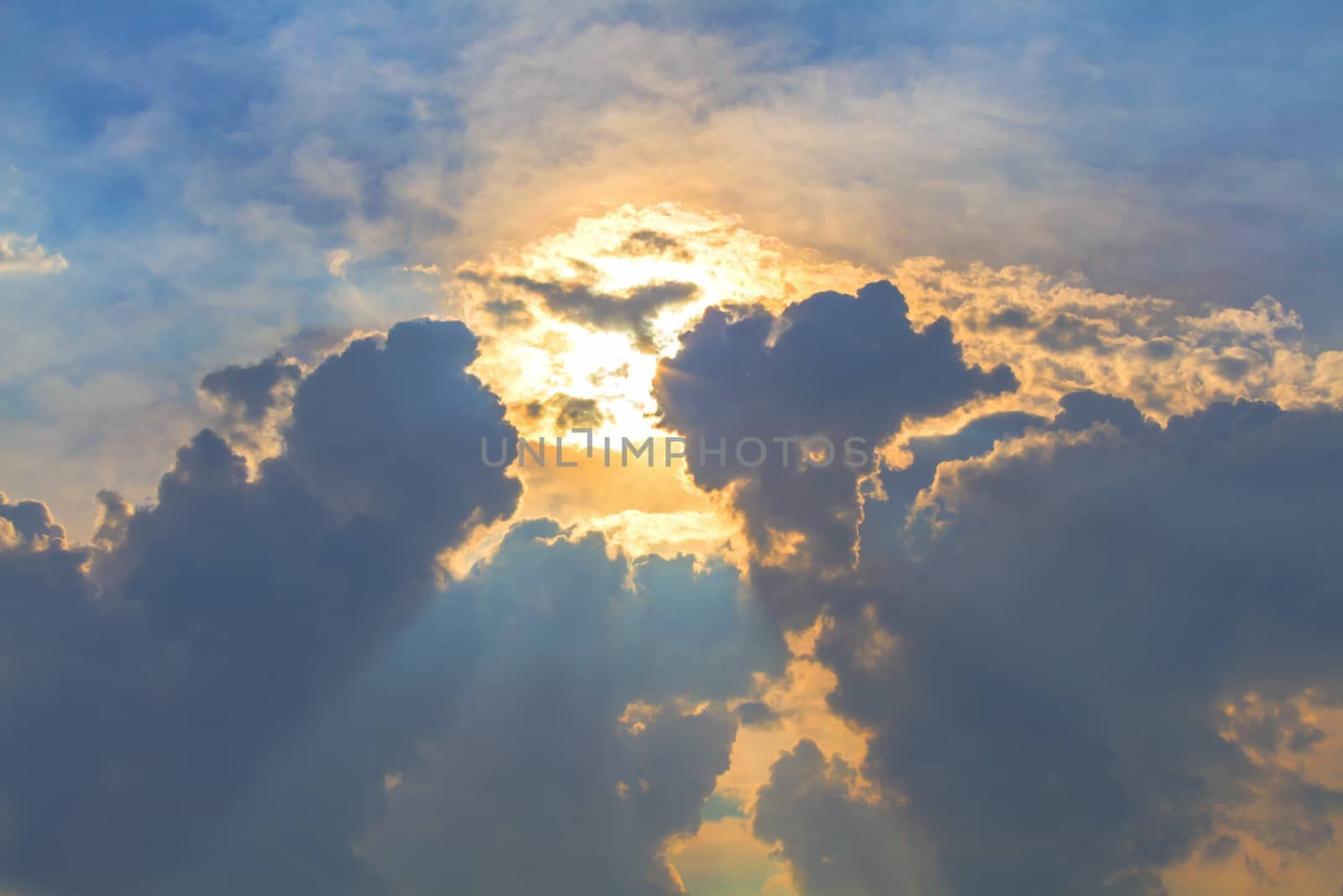 Sun under clouds on blue sky background