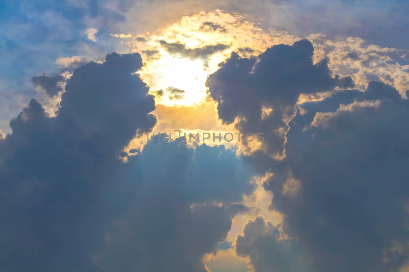 Sun under clouds on blue sky background