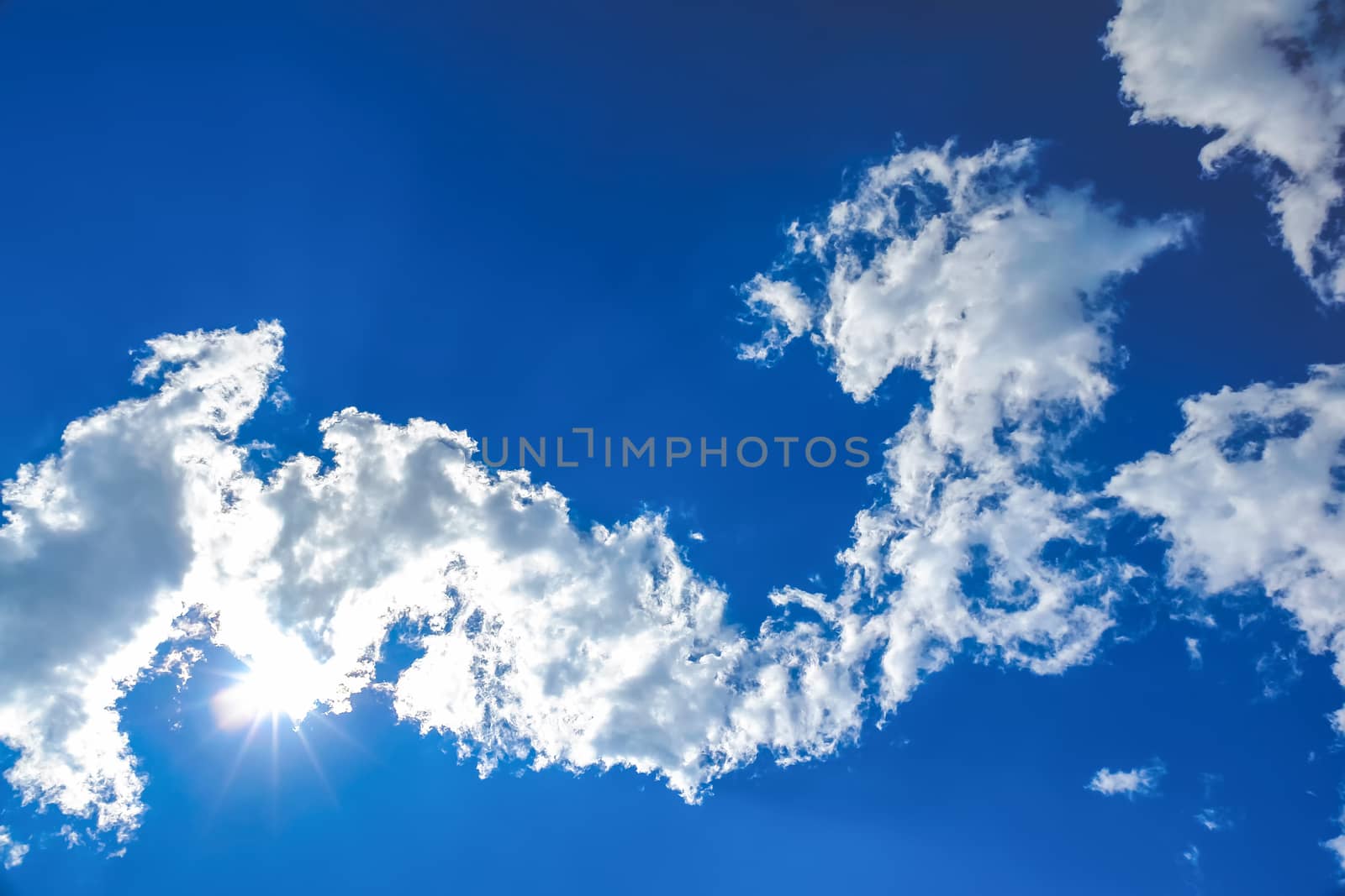 Sun and white clouds on blue sky background