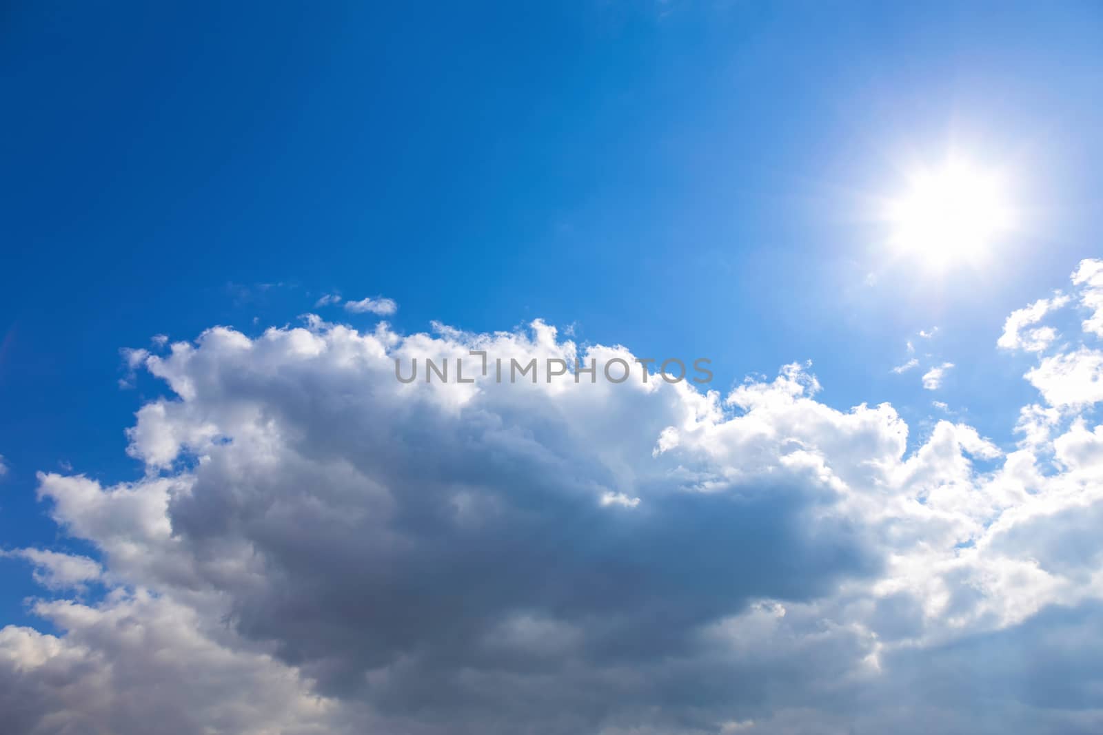 Sun and white clouds on blue sky background