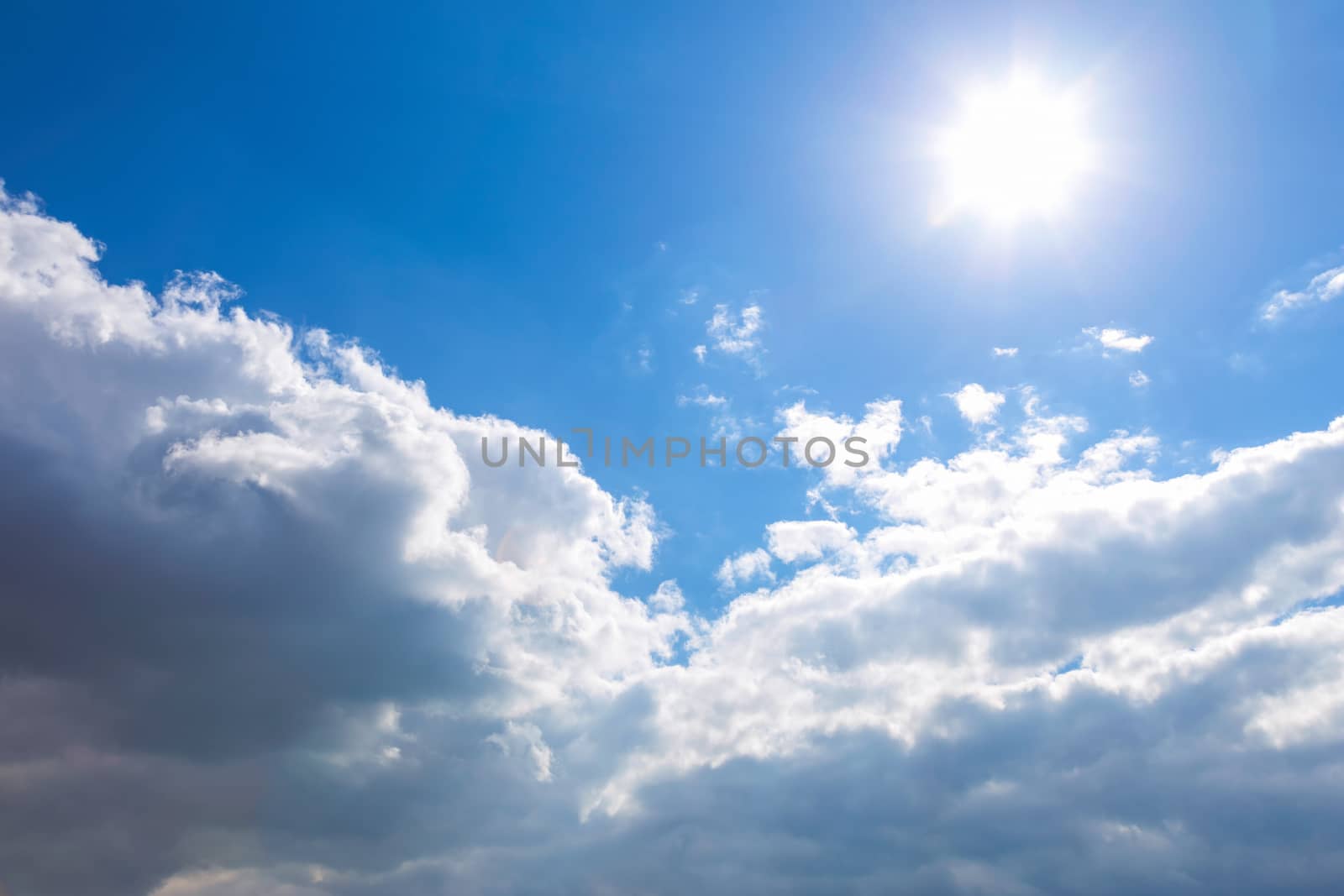 Sun and white clouds on blue sky background