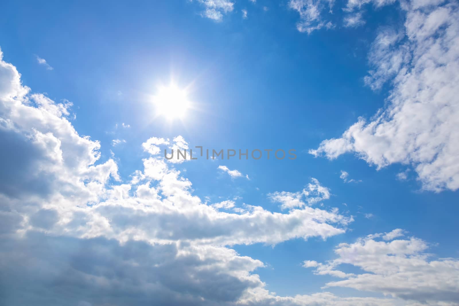 Sun and white clouds on blue sky background