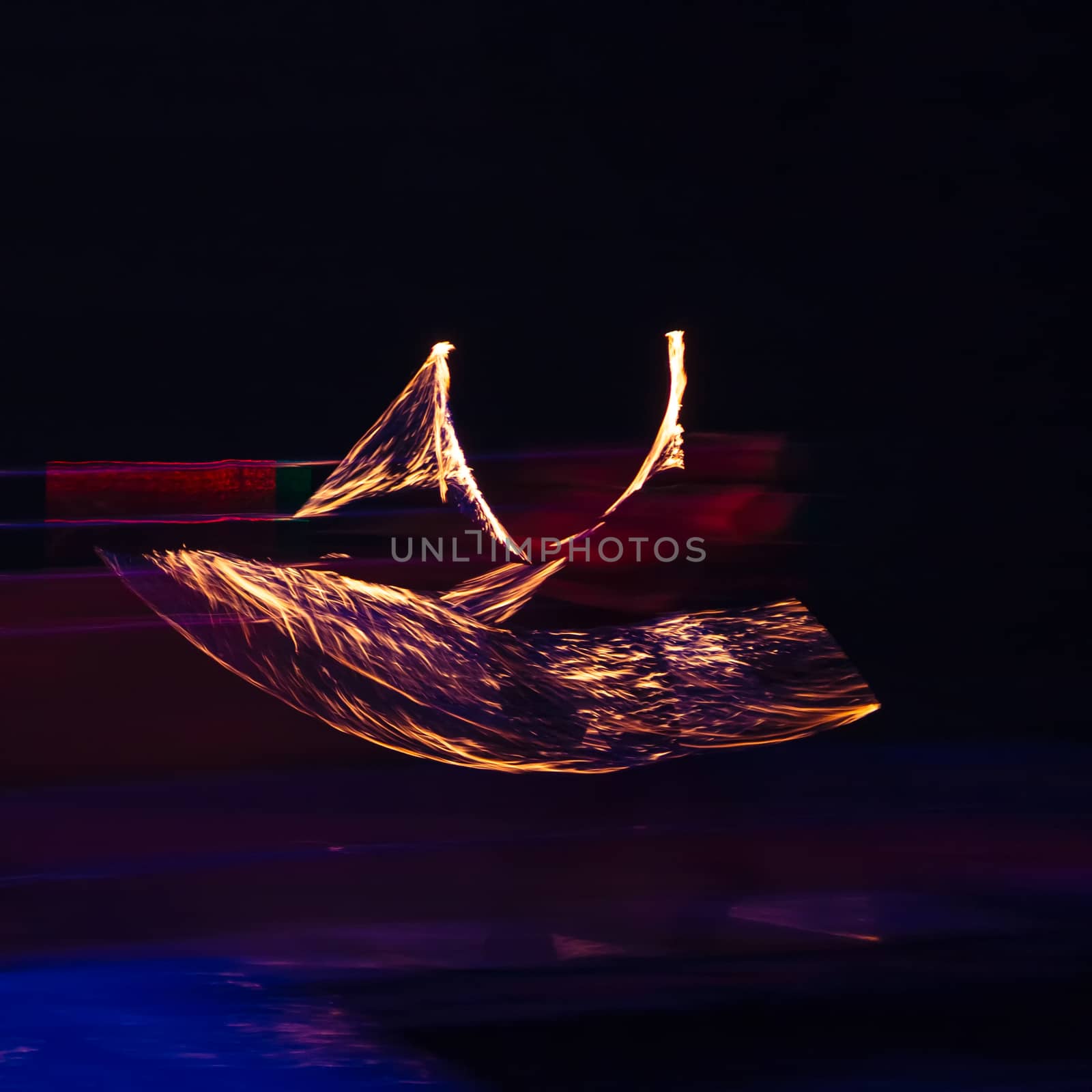 Fire performer in motion at night