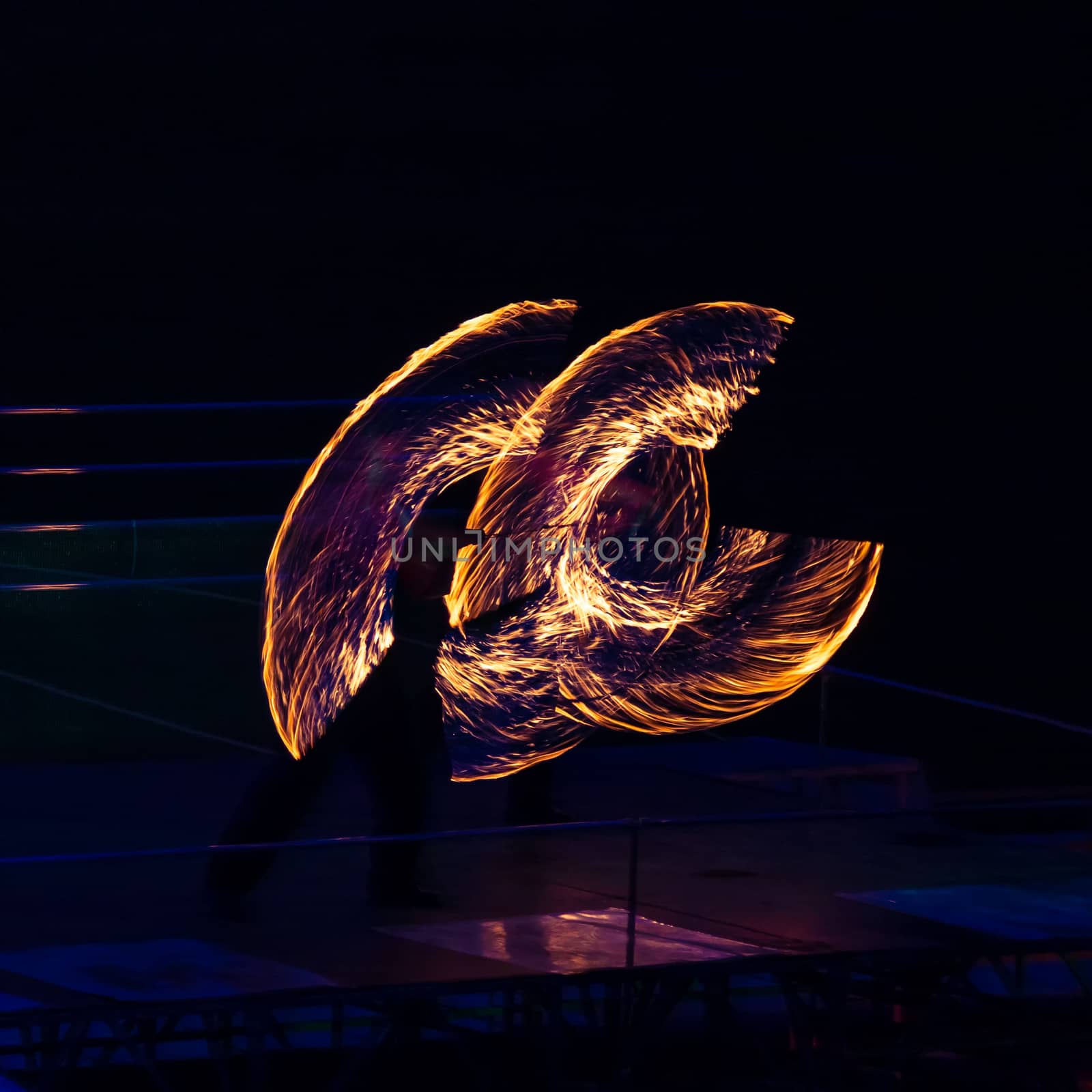Fire performer in motion at night