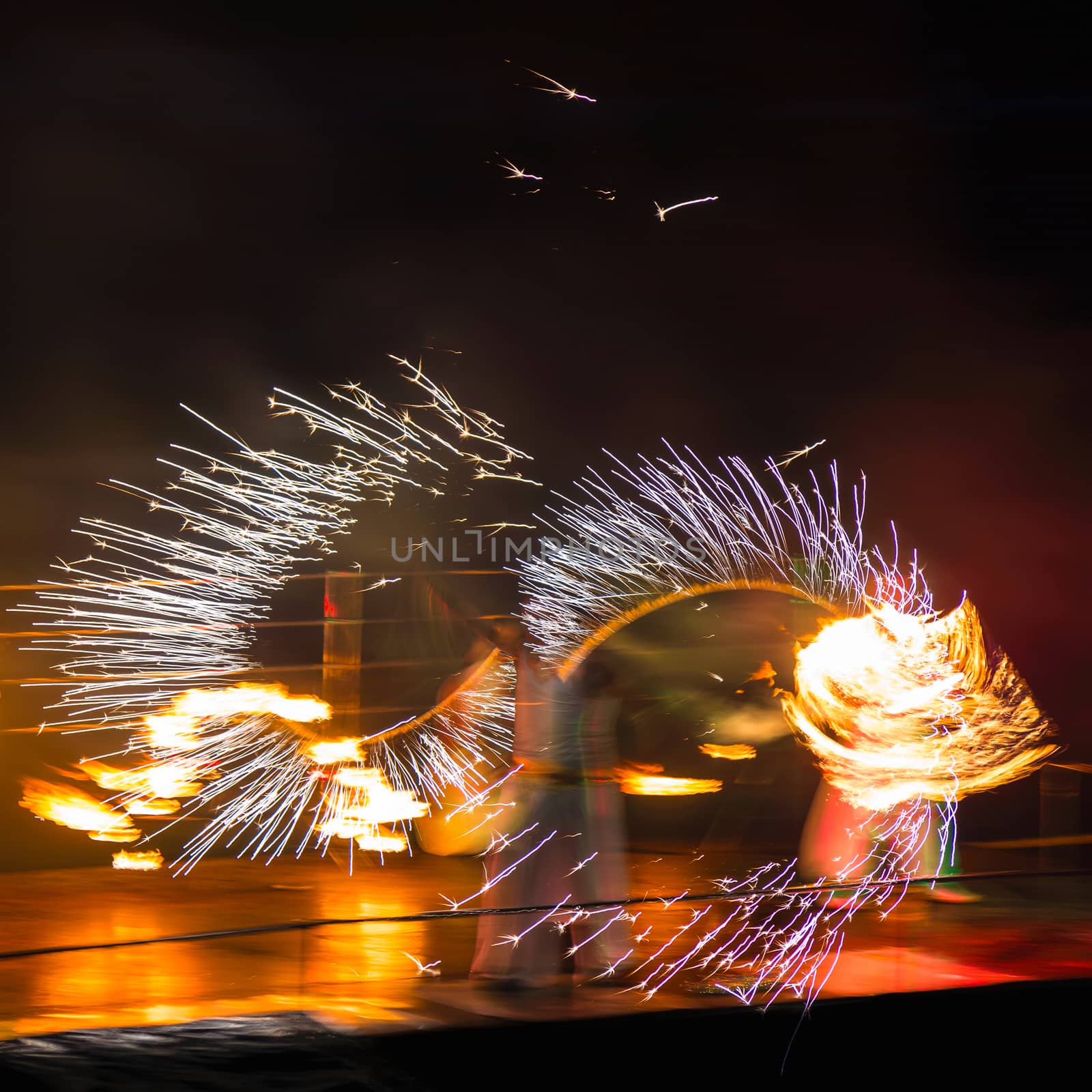Fire performers in motion at night