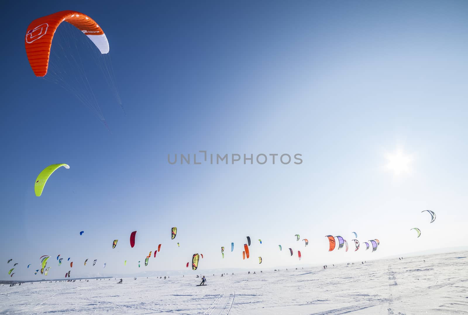 Kite surfer being pulled by his kite across the snow