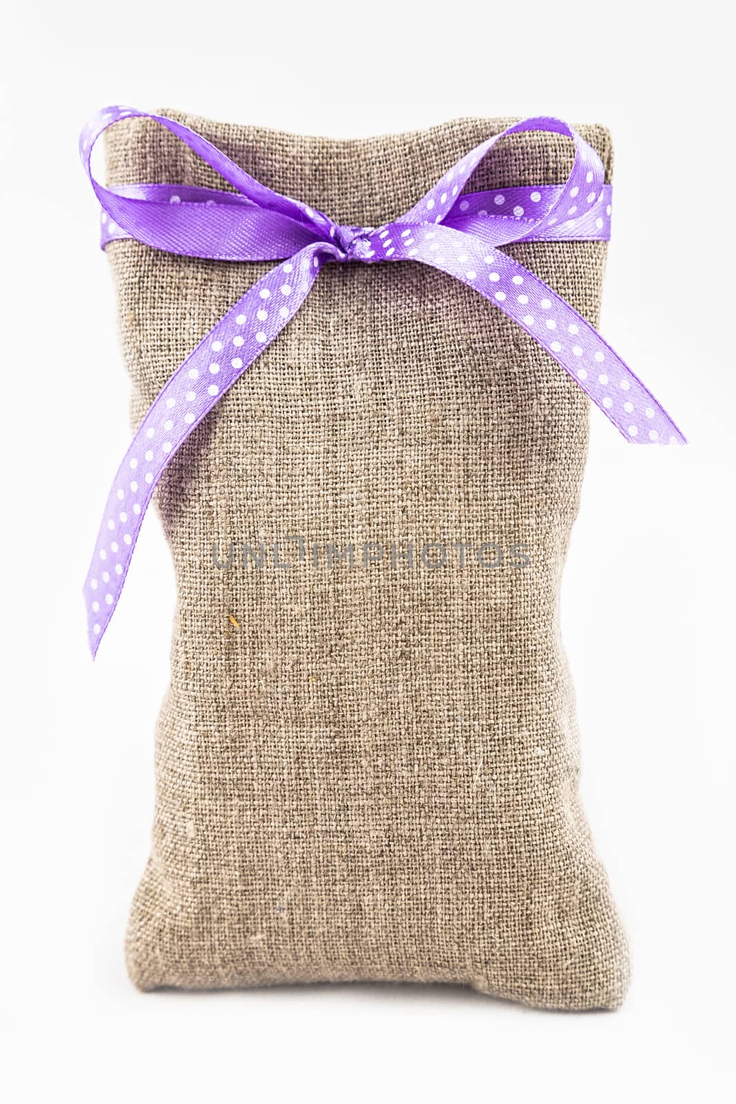 Decorative textile sachet pouch with a ribbon and bow on white background
