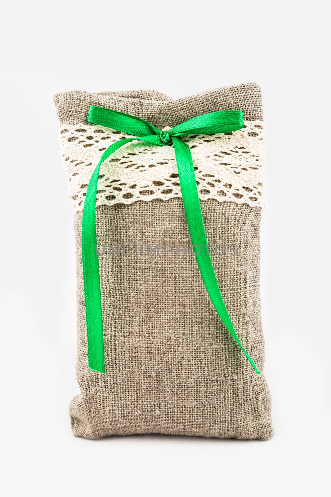 Decorative textile sachet pouch with a ribbon and bow on white background