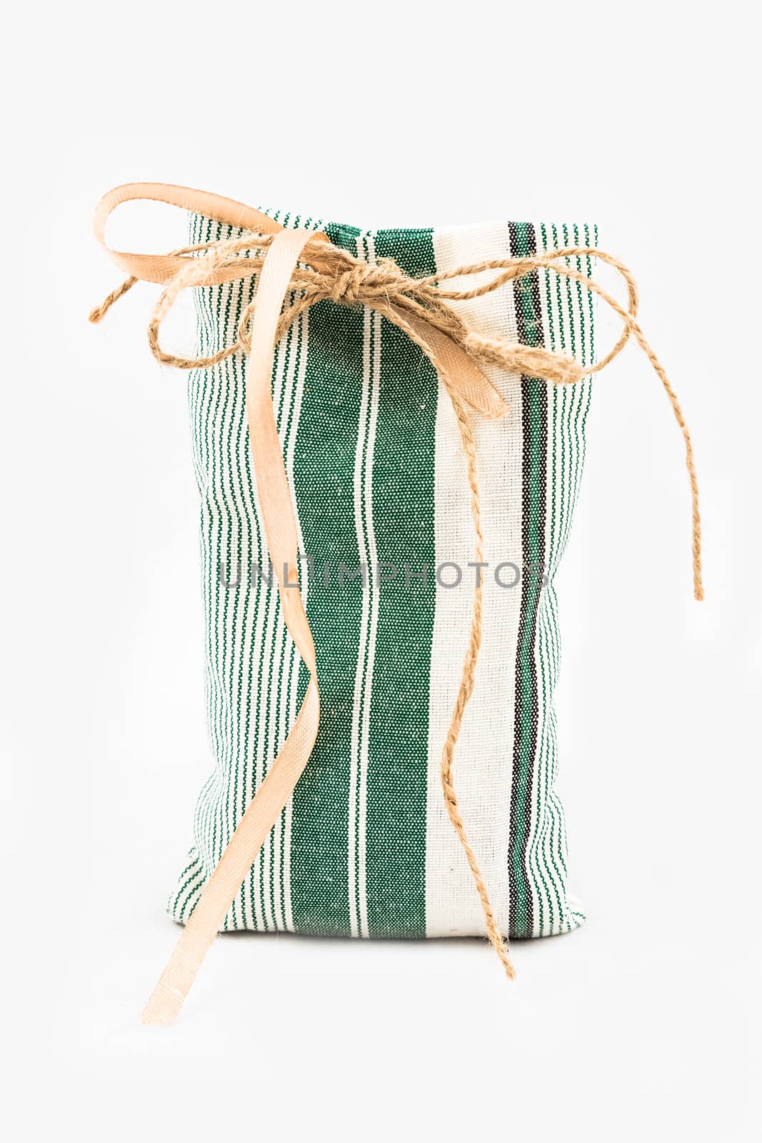 Decorative textile sachet pouch with a ribbon and bow on white background