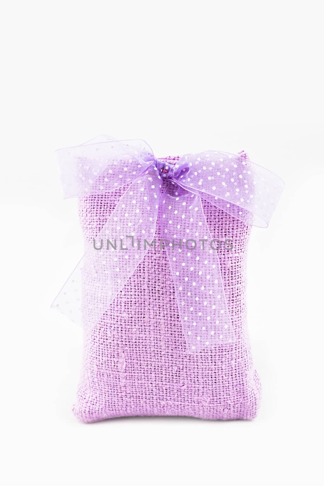 Decorative textile sachet pouch with a ribbon and bow on white background