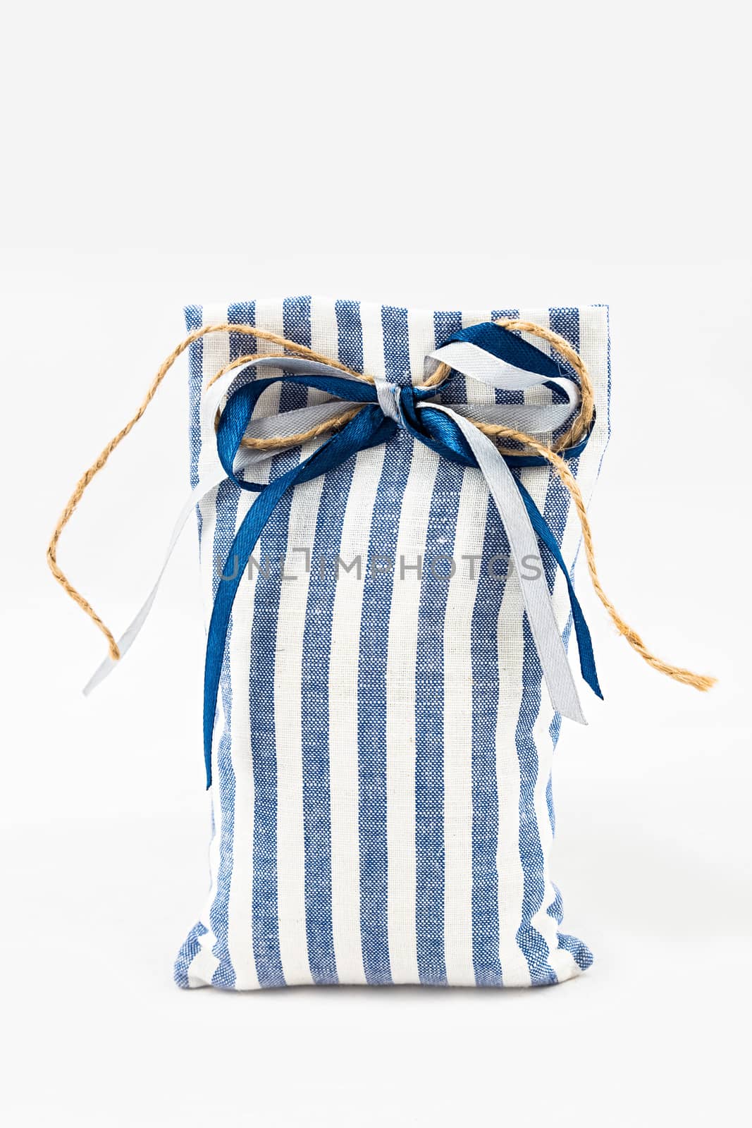 Decorative textile sachet pouch with a ribbon and bow on white background